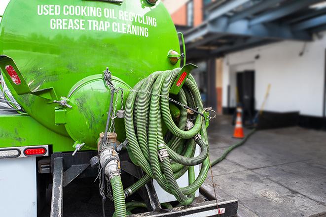 a grease trap being pumped by a sanitation technician in Boxford